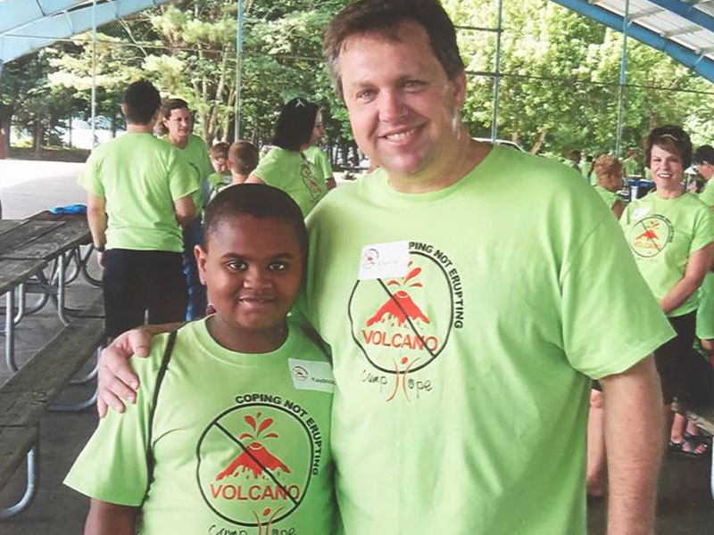 Stovall Marks Team Member with a Child at Camp Hope.
